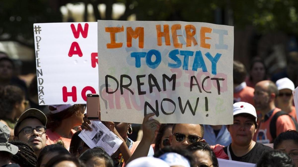 Protesters hold up signs during a rally supporting Deferred Action for Childhood Arrivals, or DACA, outside of the White House in Washington, on Tuesday, Sept. 5, 2017.