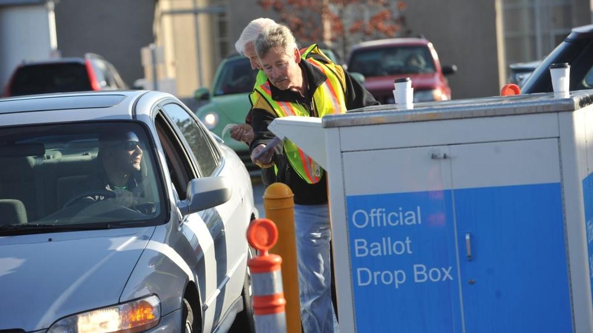 Election worker Bob Cecile puts a ballot in the new drop-off box in the parking lot south of the Whatcom County Courthouse on Grand Avenue in Bellingham on Election Day 2010. The county Auditor’s Office recommends using a drop box for last-minute ballots instead of mailing to ensure they are counted.