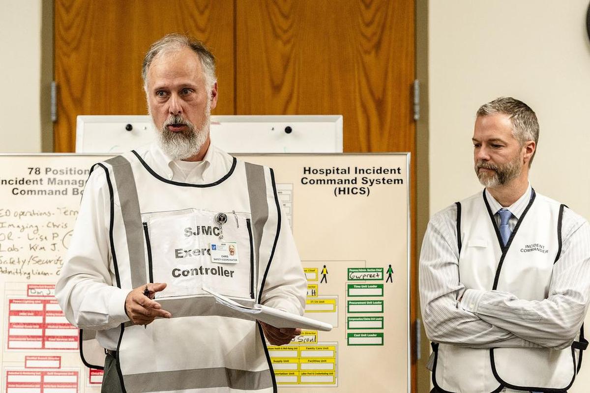 Peace Health safety coordinator Chris Hollenbeck, left, and Incident Commander Jeffery Corsentino field questions, comments, and suggestions during the evaluation phase of the Mount Baker Volcanic Eruption Exercise at St. Joseph hospital on Wednesday, Oct. 17. The purpose of the dirll is to help evaluate emergency response, medical needs, and communication requirements during natural or manmade disasters such as a volcanic eruption or earthquake. Emergency management agencies and departments from Whatcom County; Skagit County; and British Columbia, including the Royal Canadian Mounted Police; participated in the exercise to learn how to better coordinate resources in the event of major eruption at Mount Baker.