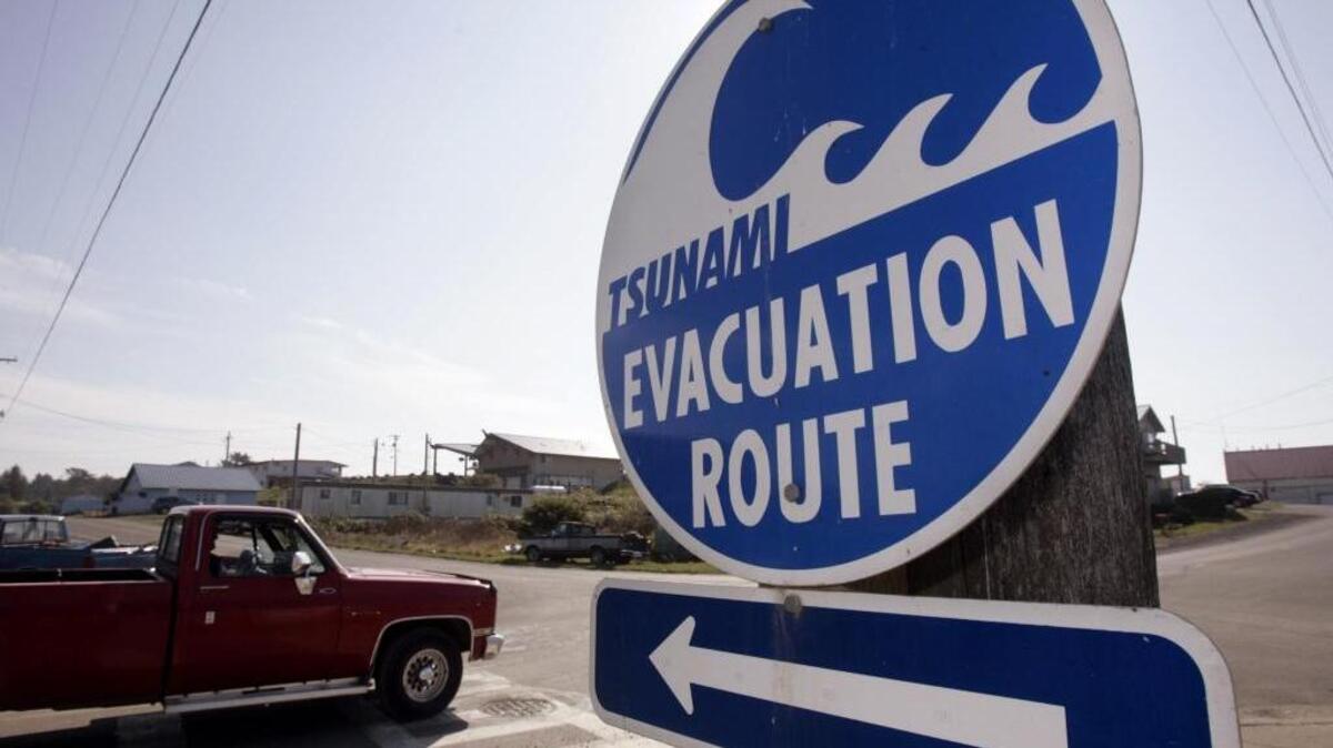 A sign directs traffic to an evacuation route in the event of a tsunami on the Quileute Indian reservation in La Push, Wash.