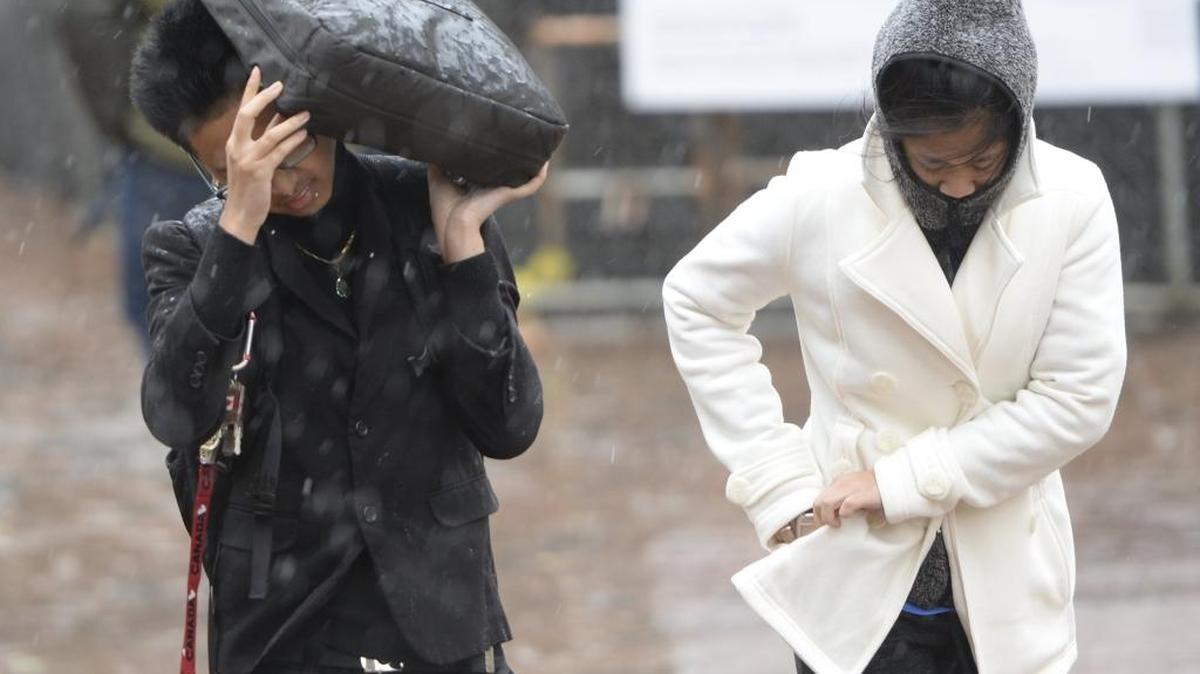 Western Washington University students Monica Serey, left, and Victoria Mao walk through the rain during a storm in Bellingham on Friday, Oct. 14, 2016.