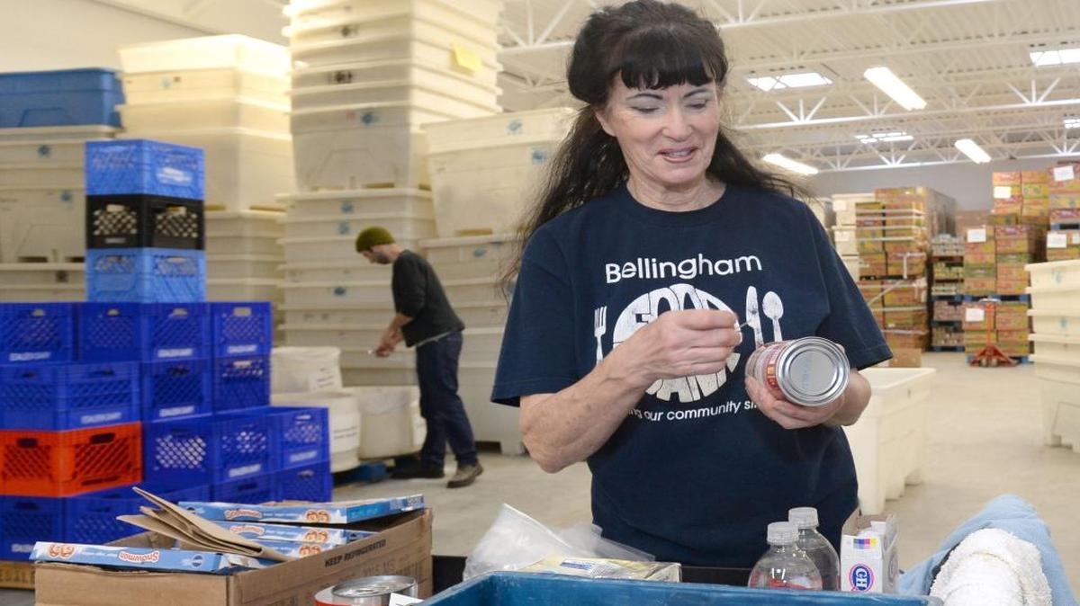 Volunteer Cherie Glahn sorts canned food in the new addition of the Bellingham Food Bank Tuesday, Jan. 19, 2016. Glahn says volunteering at the food bank is one of the “most positive things I do.” Compared to finding affordable dental care and housing, food assistance was one of the easier services for low-income Whatcom County residents to get.
