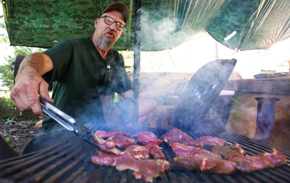 Tim Bento of Lynden grills deer meat he obtained as roadkill along a highway near his home on July 18, 2017. 