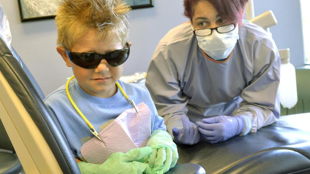Emmett Morgan acts shy during an examination with dental assistant Erin Williams at the health fair in 2015, when Unity Care NW was called the Interfaith Community Health Center.