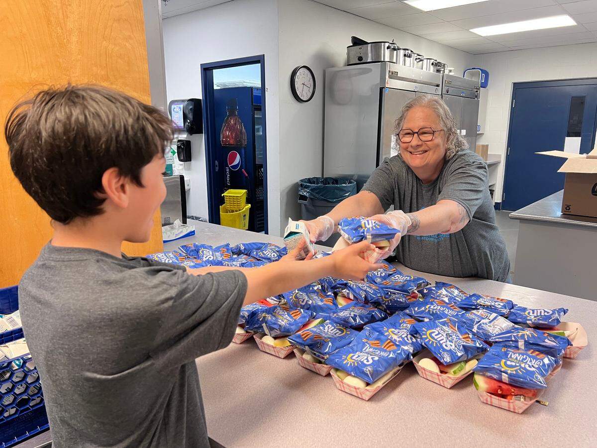 Lynn Schreiber, Boys and Girls Club of Whatcom County Director provides a child with a free meal over the summer. The meals are available to all kids 18 and under.