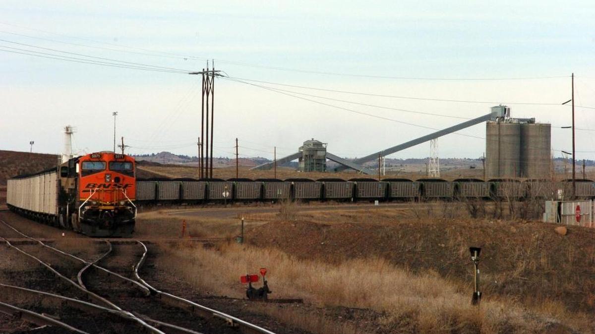 In this Jan. 16, 2013 photo, a coal train idles in front of the Decker Coal Mine near the Wyoming border in Decker, Mont. The mine once produced 10 million tons of coal a year “like clockwork,” but is now down to less than a third of that volume as contracts dry up amid slackening demand for the fuel.