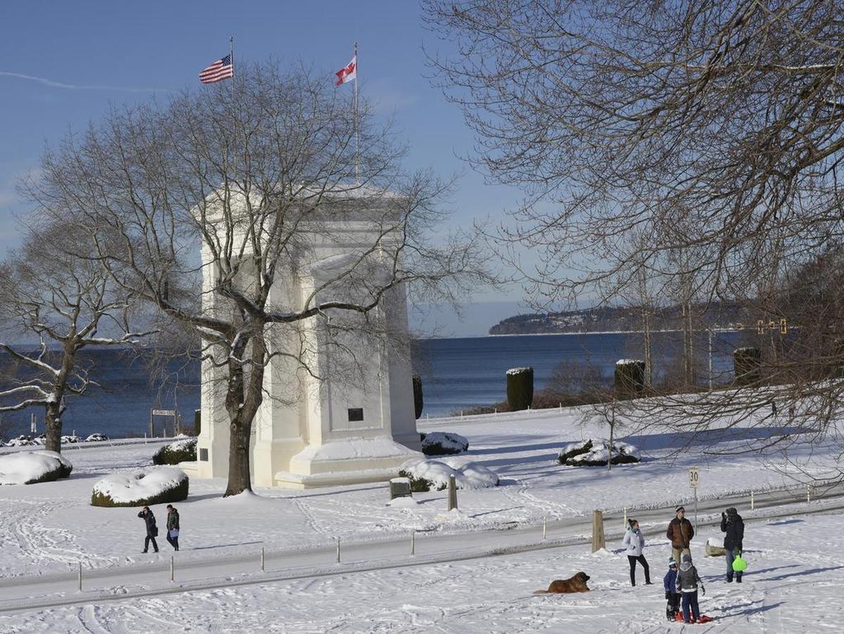 Visitors from both sides of the U.S.-Canada border enjoy the Peace Arch Park in the snow and sunshine Monday, Feb. 7, 2017. A federal investigation uncovered a human smuggling network that may have helped nearly 1,000 Chinese migrants cross the Canada-U.S. border via the Peace Arch Park that straddles the border near Blaine.