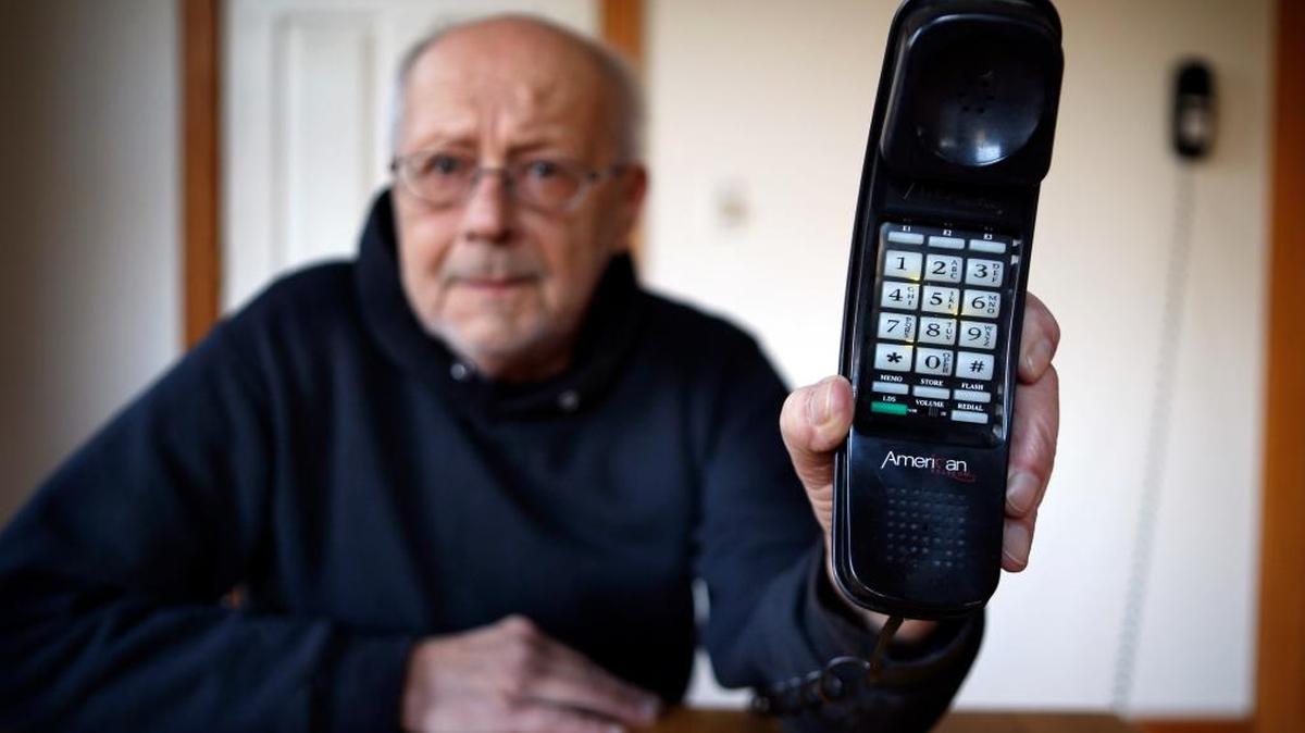 Peter Froehlich holds the landline telephone he uses at his rural home in Whitefield, Maine, in April, 2016. Across the country, telecom companies are lobbying lawmakers to be released from their mandate of providing service to every home.
