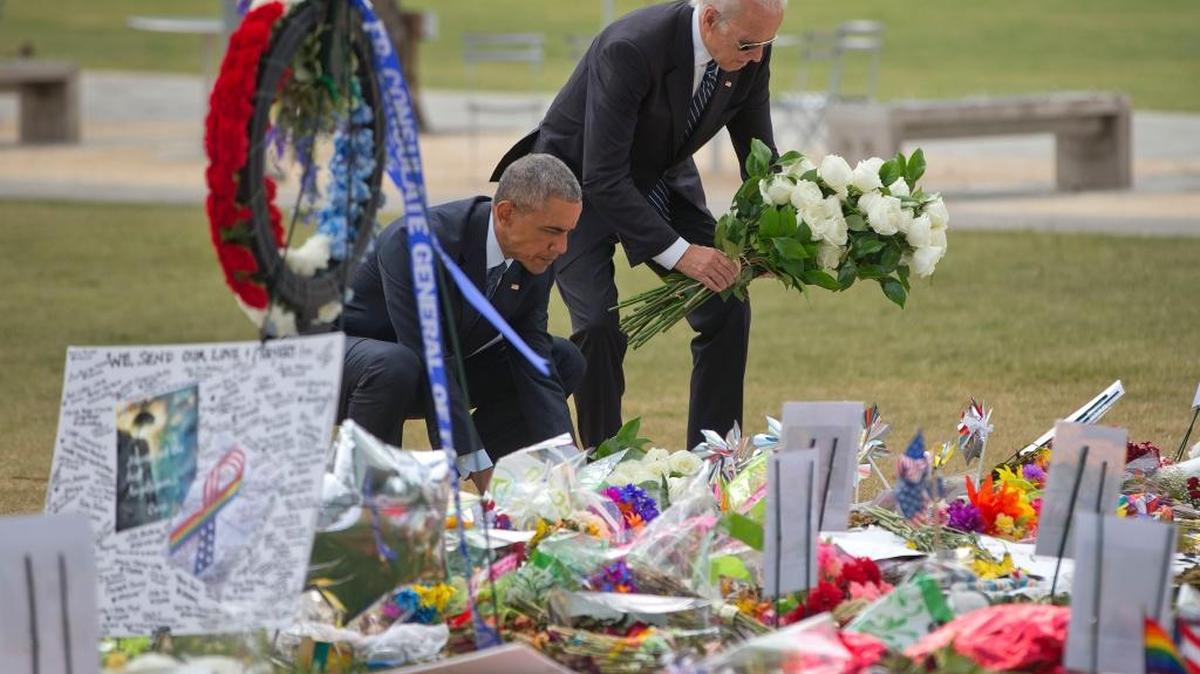 President Barack Obama and Vice President Joe Biden place flowers down during their visit to a memorial to the victims of the Pulse nightclub shooting, Thursday, June 16, 2016 in Orlando, Fla. Offering sympathy but no easy answers, Obama came to Orlando to try to console those mourning the deadliest shooting in modern U.S history.