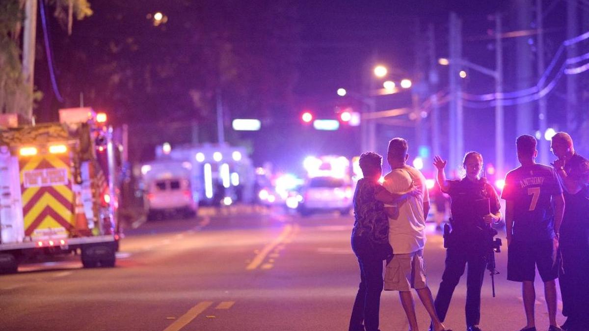 Orlando police officers direct family members away from the scene of the shooting at the Pulse Orlando nightclub in Orlando, Fla., early Sunday, June 12.