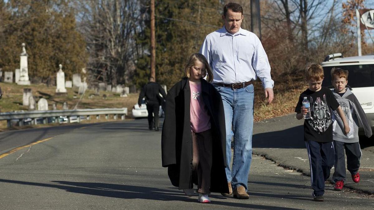 David Connors walks away from the scene of the Sandy Hook Elementary School shooting with his children in Newtown, Conn., Dec. 14, 2012. Twenty-six people died in the attack, including 20 children. A lawsuit brought by relatives of the shooting victims in Connecticut argues that the AR-15 is a weapon of war and should never have been marketed to civilians.