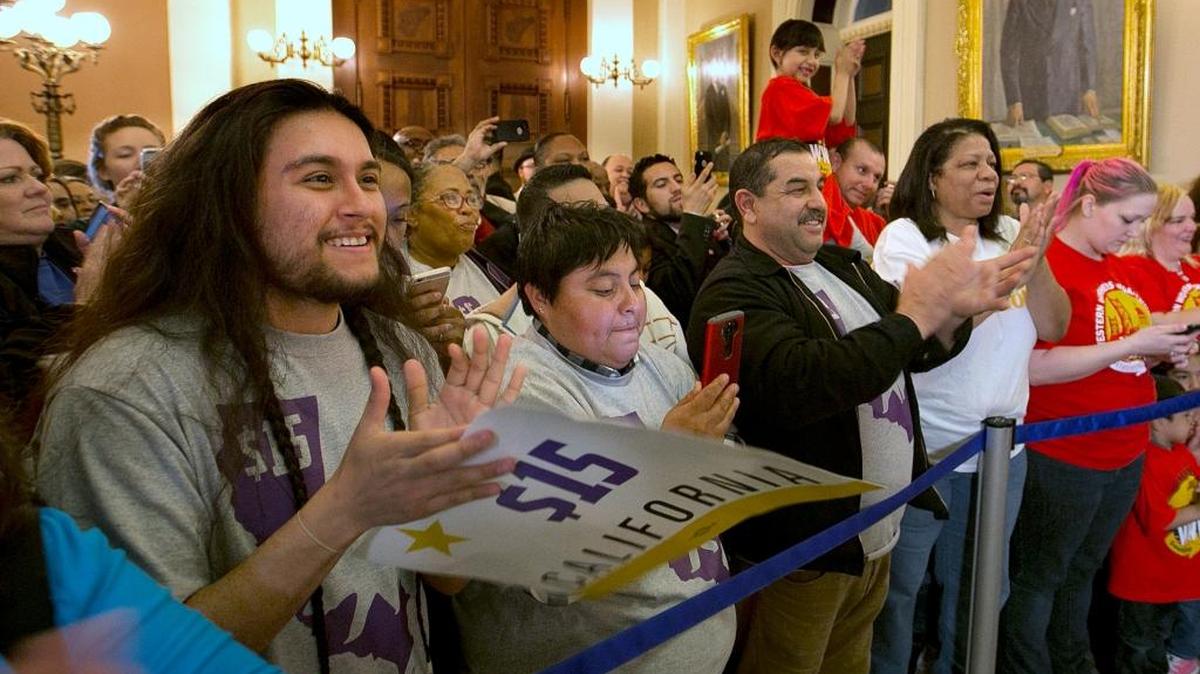 Supporters of a bill to raise California’s minimum wage celebrate outside the state Senate Chamber after the measure was approved by the Senate Thursday, March 31, 2016, in Sacramento, Calif. The bill will gradually raise California’s minimum wage to a nation-leading $15 an hour by 2022.