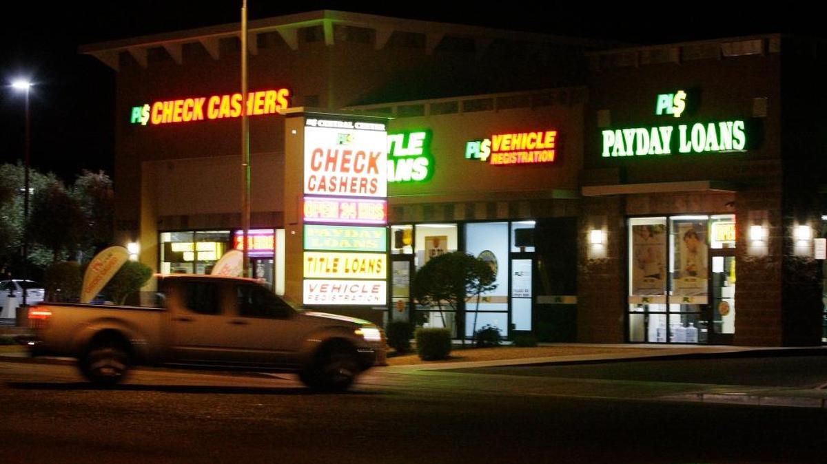 Neon signs illuminate this payday loan business, one of 650 operating in the state and some open 24 a day in 2010, in Phoenix. Proposed federal rules would generally require lenders to verify that borrowers can afford the loans and cap the number of times people can take out successive loans.