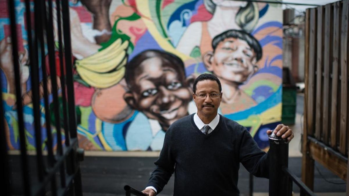 Lawrence Taylor is a job counselor at Jubilee Jobs in Washington. The Move Up program at Jubilee Jobs helps people transition from entry-level jobs into positions that make a livable wage. A mural is painted on the building behind his workplace.