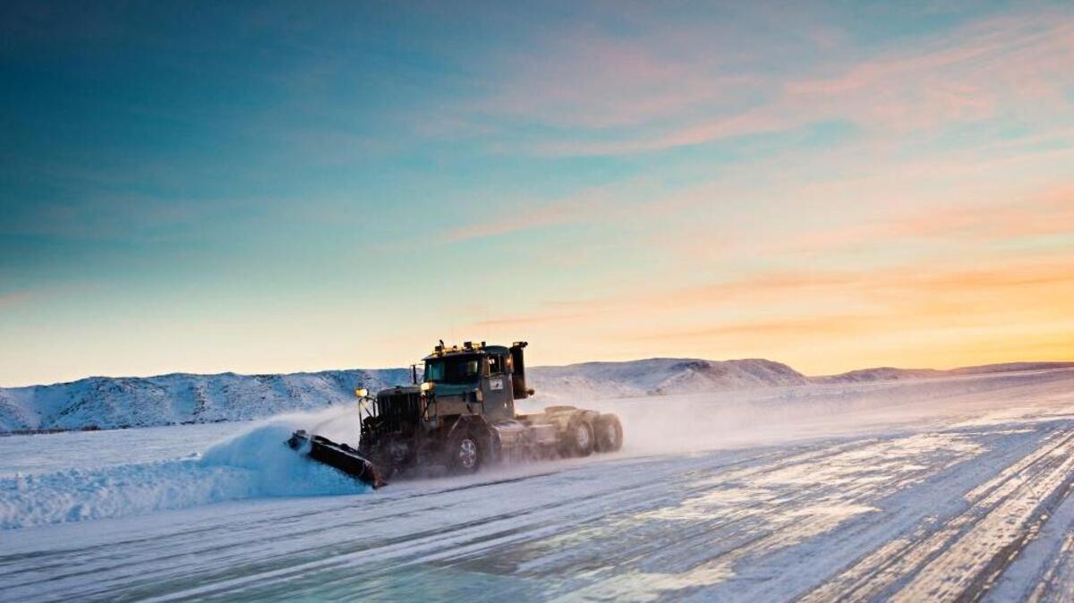 A plow truck clears the shoulder of an ice road in Inuvik, Northwest Territories, Canada.