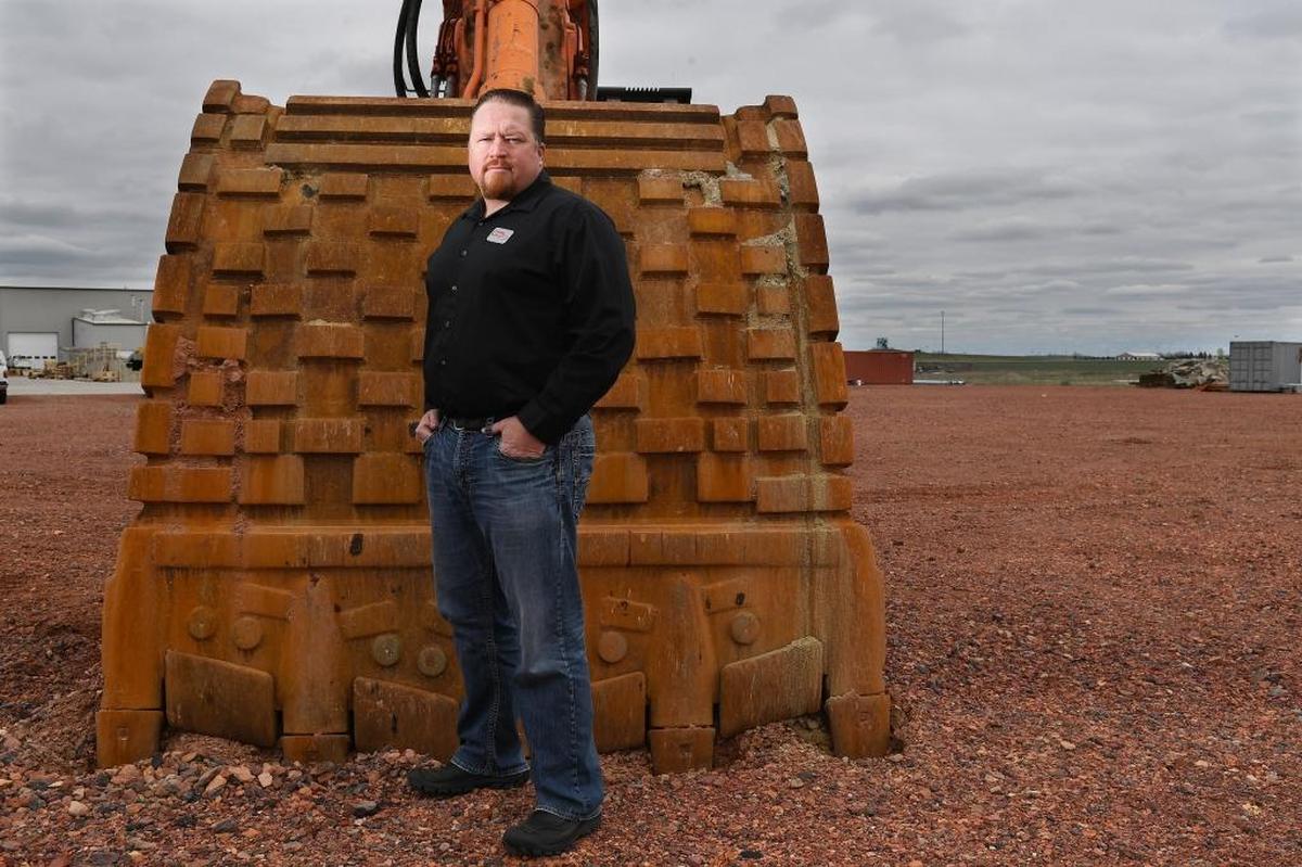 Adam Coleman of Arnold Machinery stands in front of an excavator in Gillette, Wyoming. “Trump will be good for all of us in the long term,” he said. “He’s not scaring people away from us.”