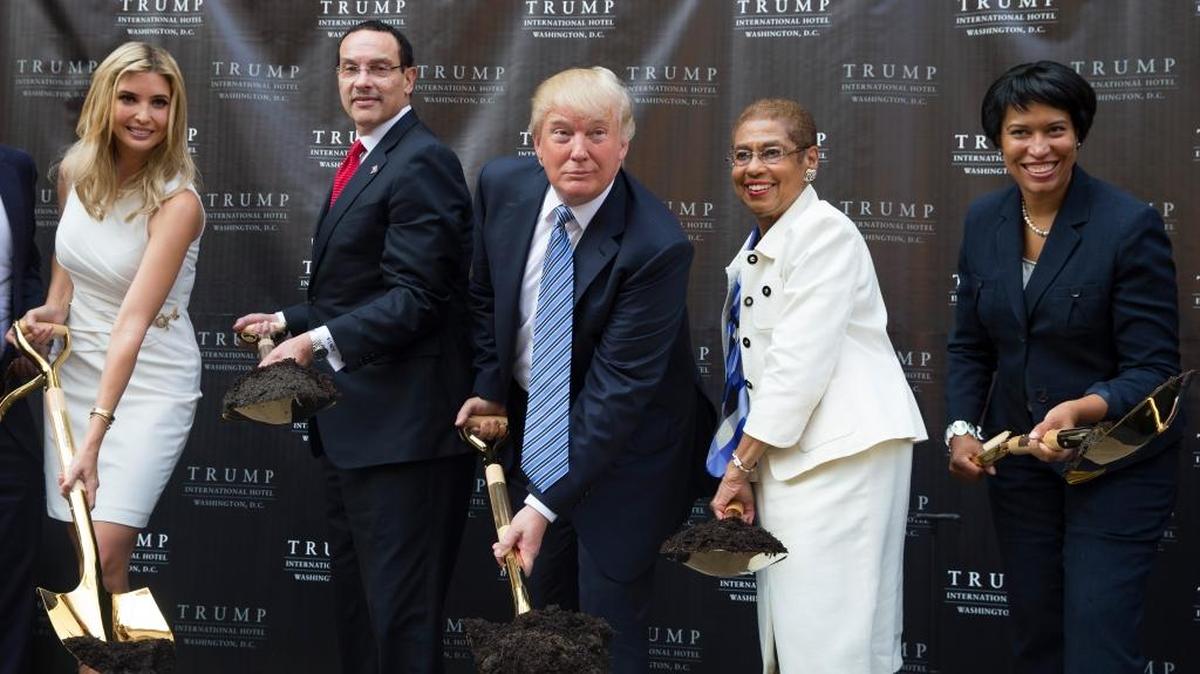 Donald Trump, center, poses for photographs during a ground breaking ceremony for the Trump International Hotel on the site of the Old Post Office, in 2014, in Washington.