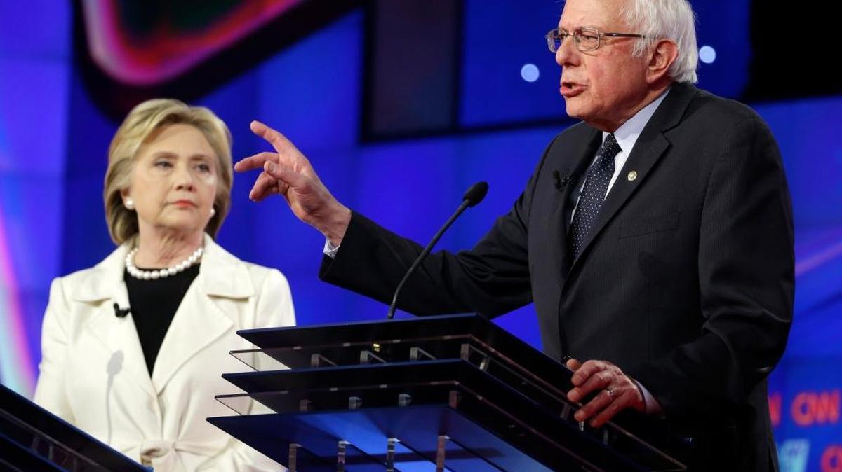 Democratic presidential candidate Sen. Bernie Sanders, I-Vermont, right, speaks as Hillary Clinton listens during the CNN Democratic Presidential Primary Debate at the Brooklyn Navy Yard on Thursday, April 14, 2016 in New York. The former U.S. senator and secretary of state has abandoned the centrist positions she previously held on trade and Social Security and taken stances closer to Sanders’s views.