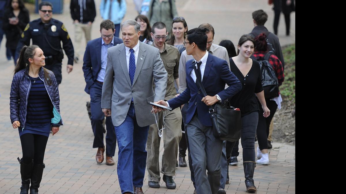 
Western Washington University student Therese Claire, left, walks with Washington Gov. Jay Inslee and WWU student Dylan Green, through the Bellingham campus on March 2, 2015. Inslee talked to students about education, climate change and tuition.
