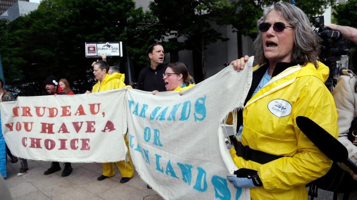 Demonstrators protesting Canada’s Trans Mountain Pipeline expansion chant as Canada Prime Minister Justin Trudeau leaves a hotel steps away following a meeting May 2017, in Seattle. Indigenous leaders from along the pipeline route and the U.S. are expected to join a march and rally beginning Saturday in metro Vancouver.