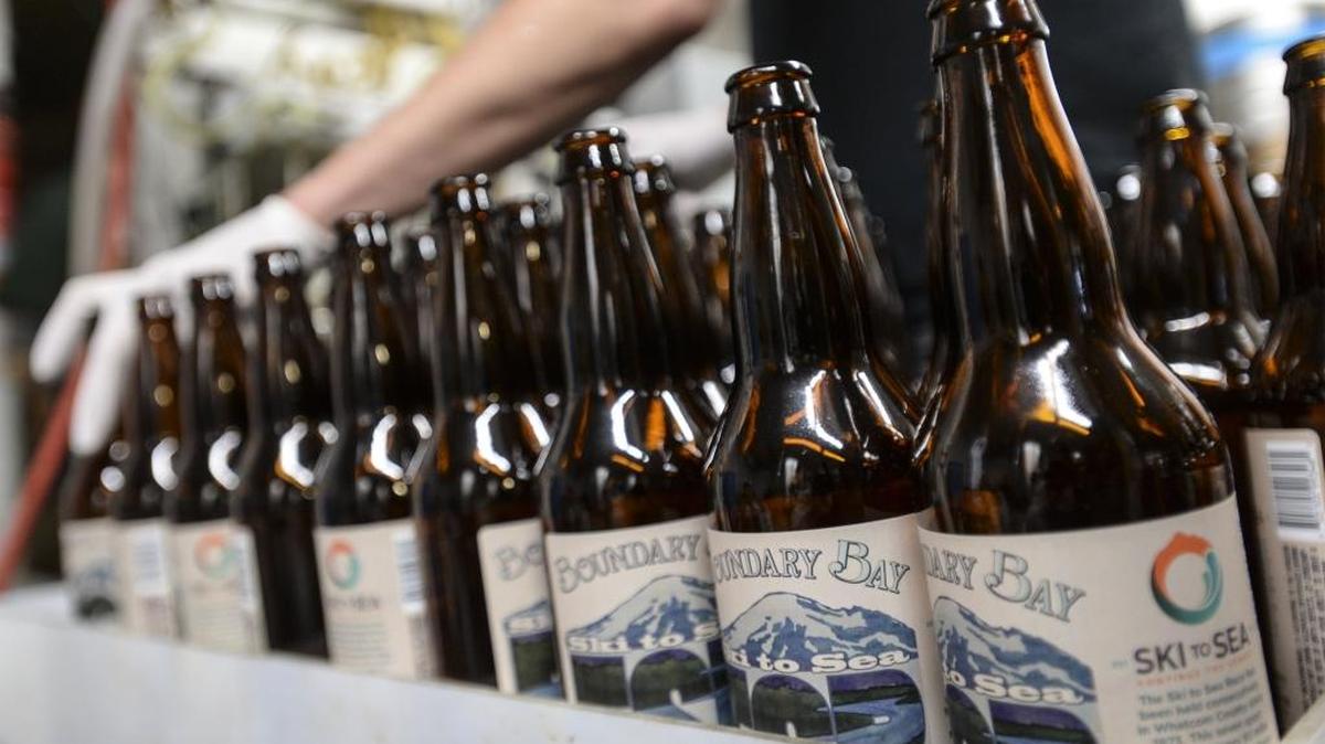 Aaron Skinner lines up beer bottles while bottling the special 2016 Ski to Sea beer at Boundary Bay Brewery in Bellingham.