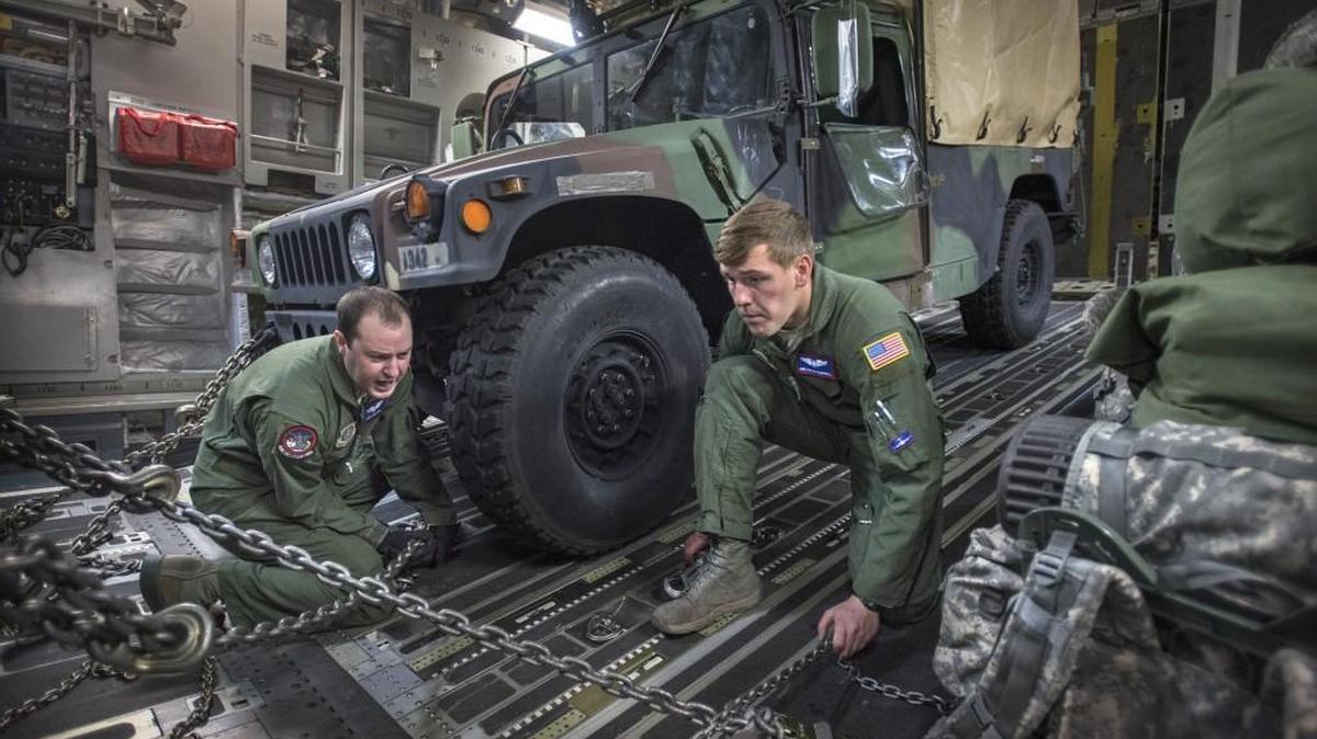Staff Sgt. Jon Fabis, left, and Airman Austin Campbell secure I Corps vehicles and equipment inside an Air Force C-17 transport as they prepare Wednesday for a flight to Naval Air Station Whidbey Island during a rehearsal exercise for rapid deployment of the early entry command post from McChord Field at Joint Base Lewis-McChord.