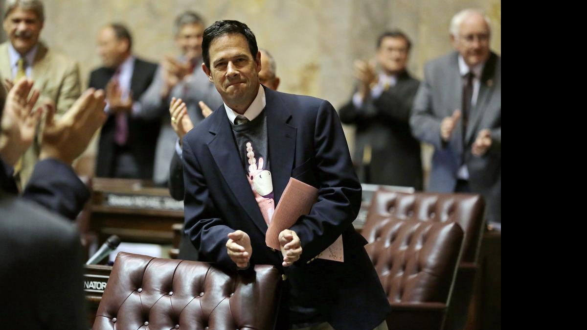 
State Sen. Andy Hill, R-Redmond, the Washington Senate's chief budget writer, applauds staff members on the Senate floor June 30 after the Senate passed the $3.9 billion state construction budget during a late-night session at the Capitol in Olympia. Hill is wearing a T-shirt with the image of the Senate Ways and Means committee mascot, the “Balloonicorn” character from the Team Fortress 2 video game. 
