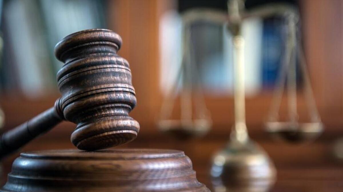 Law and Justice concept. Mallet of the judge, books, scales of justice. Gray stone background, reflections on the floor, place for typography. Courtroom theme.