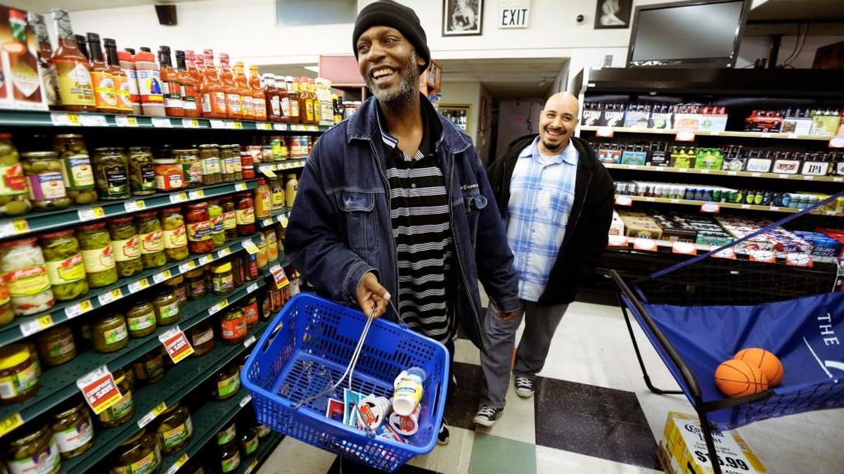 Jerald Brooks, left, one of the original participants in a Seattle program called Law Enforcement Assisted Diversion, goes shopping for groceries March 25 with Chris Cates, his caseworker, in Seattle. Funding from the expansion of Medicaid brought on by Obamacare in some states has made repeat drug offenders such as Brooks eligible for coverage, which could be a new tool for shifting addicts out of the criminal-justice system as an alternative to the drug war.