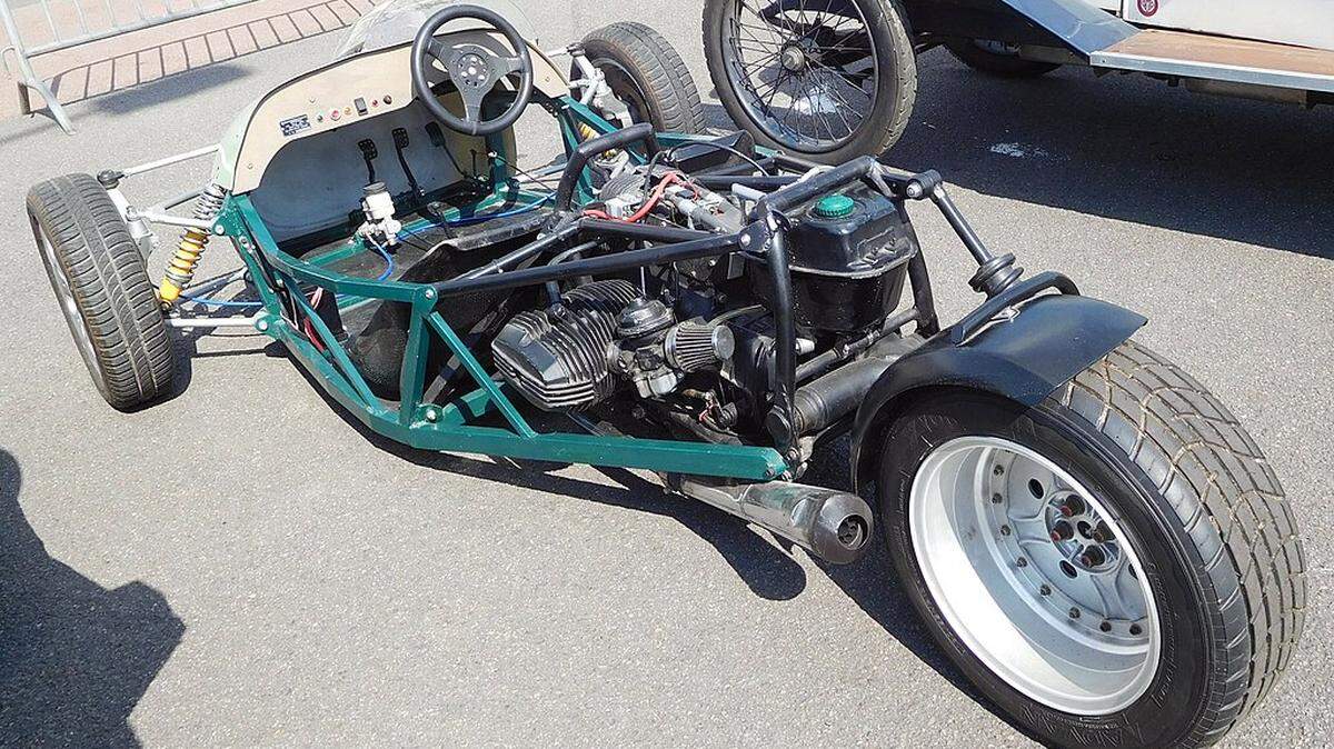 A two-seat, three-wheeled racing motor vehicle with BMW flat-twin motorcycle engine.        