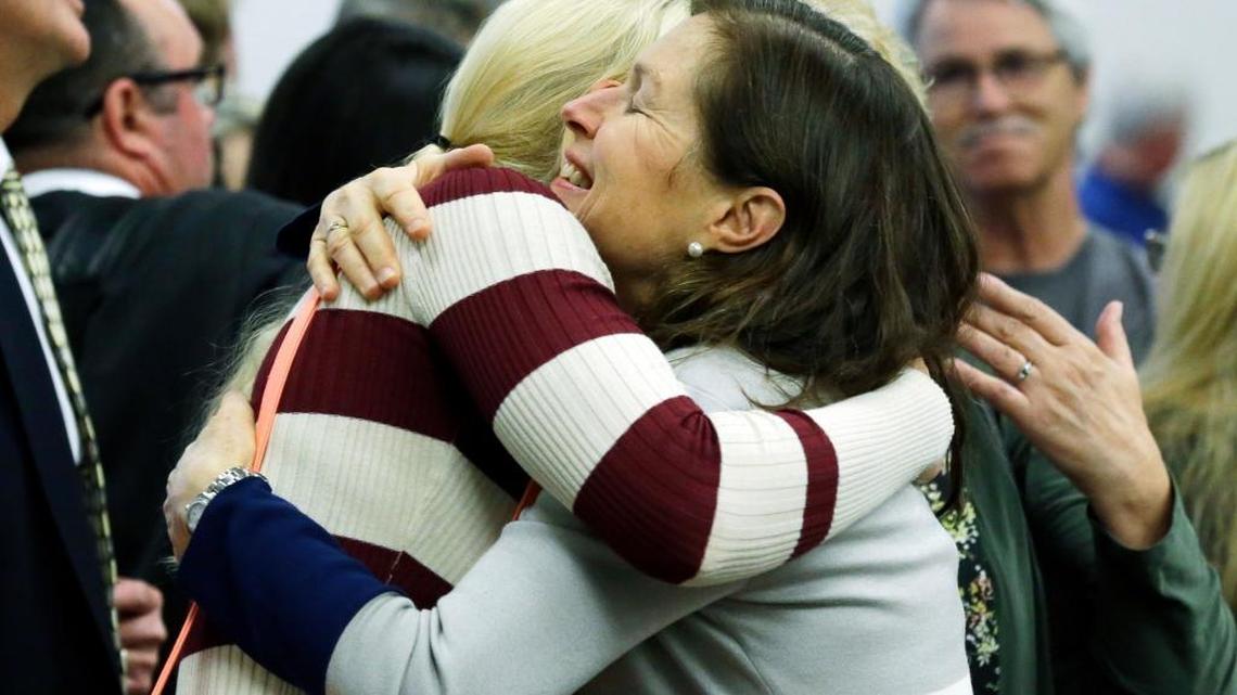Corrie Yackulic, right, an attorney representing several family members of victims of a 2014 Oso, Wash., landslide, hugs Lisa Bevjl, left, who lost her brother Alan in the slide, in King County Superior Court, Monday, Oct. 10, 2016, in Seattle after it was announced that a settlement had been reached in a lawsuit brought by survivors and family members of people killed in the slide against the state of Washington and a timber company that logged an area above the site of the slide.