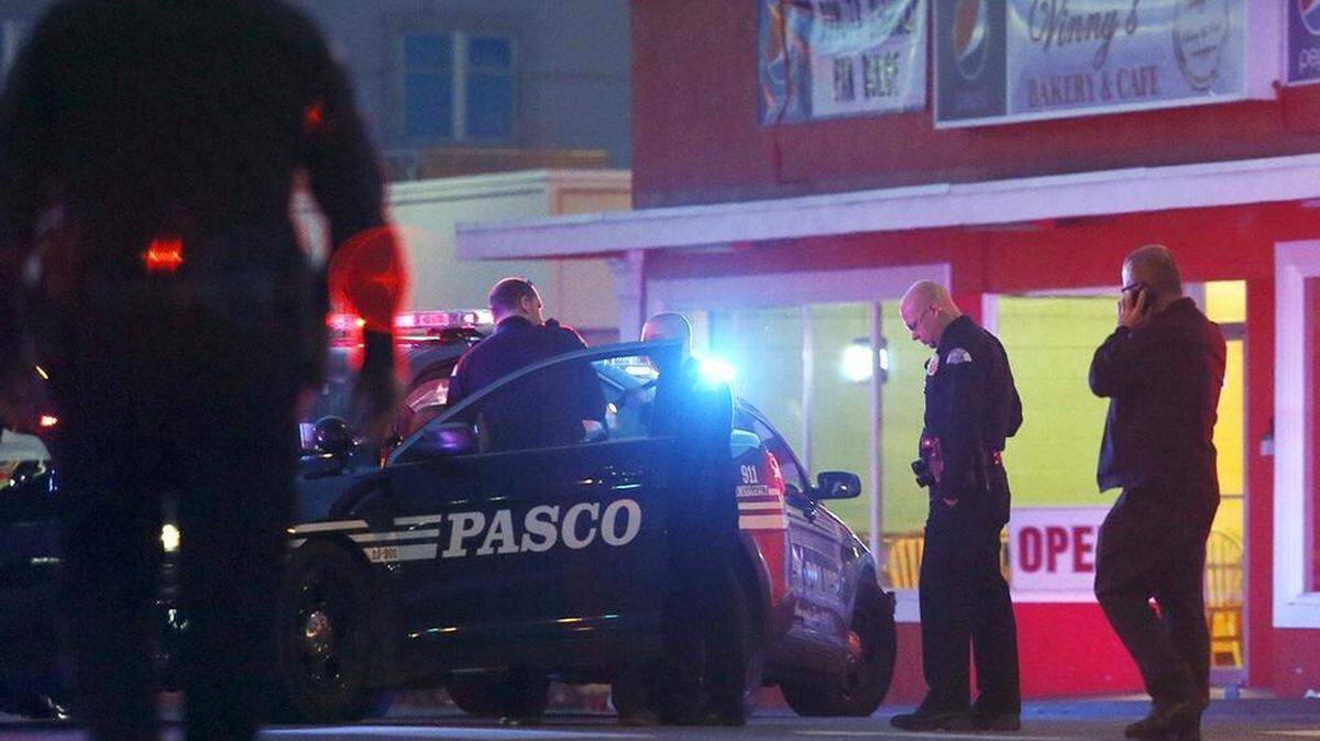 Pasco police officers gather outside of Vinny's Bakery and Cafe on 10th Avenue and Lewis Street in Pasco on February 10, 2015, following the shooting death of Antonio Zambrano-Montes by three Pasco police officers.