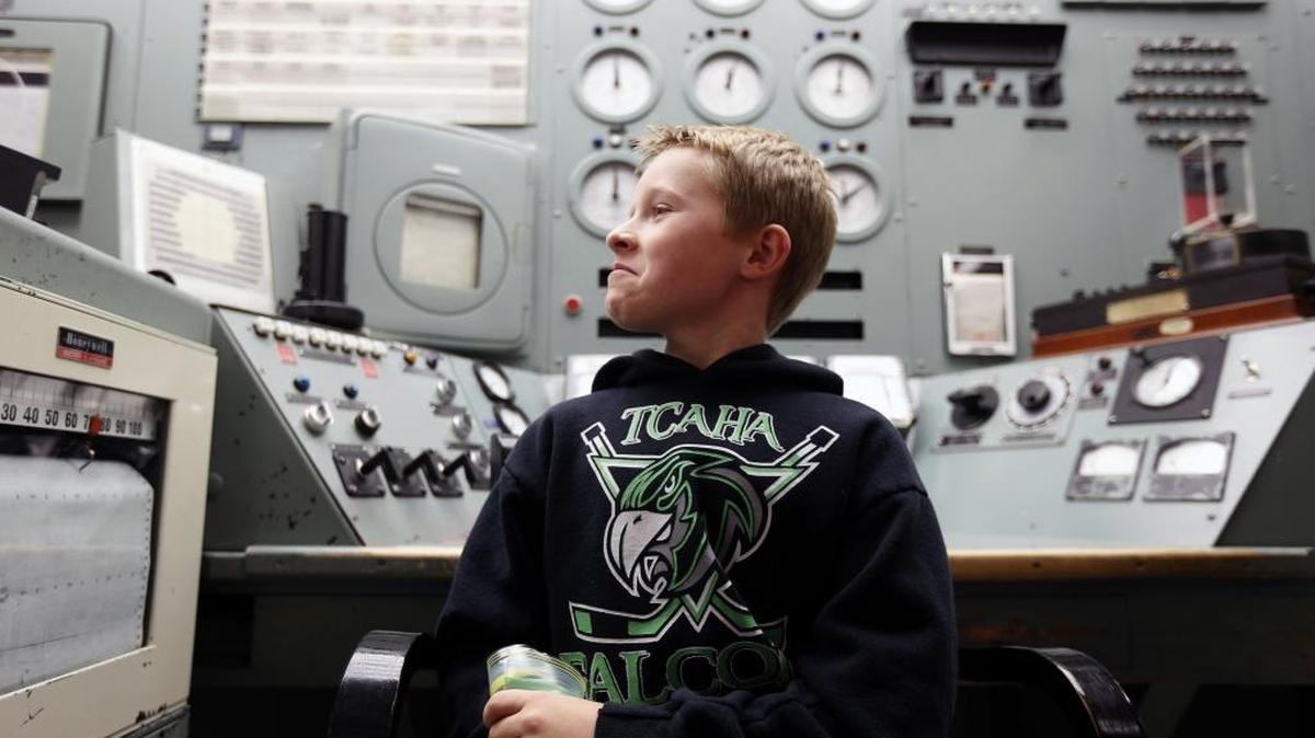 Tyler Vincent, a fourth-grade student from White Bluffs Elementary School, sits in the operator’s chair in the control room of B Reactor during a tour Thursday.