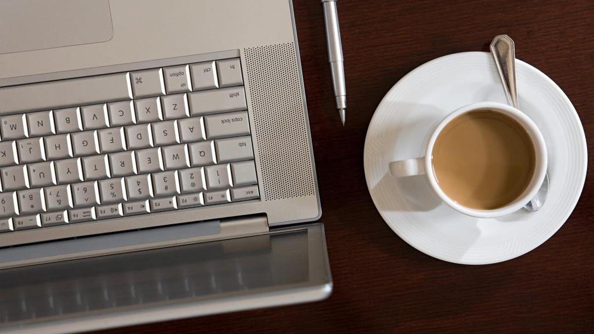 A laptop, pen and cup of coffee are positioned on a table. California state jobs are known for offering competitive benefits and enrollment in the nation’s largest state public pension plan.