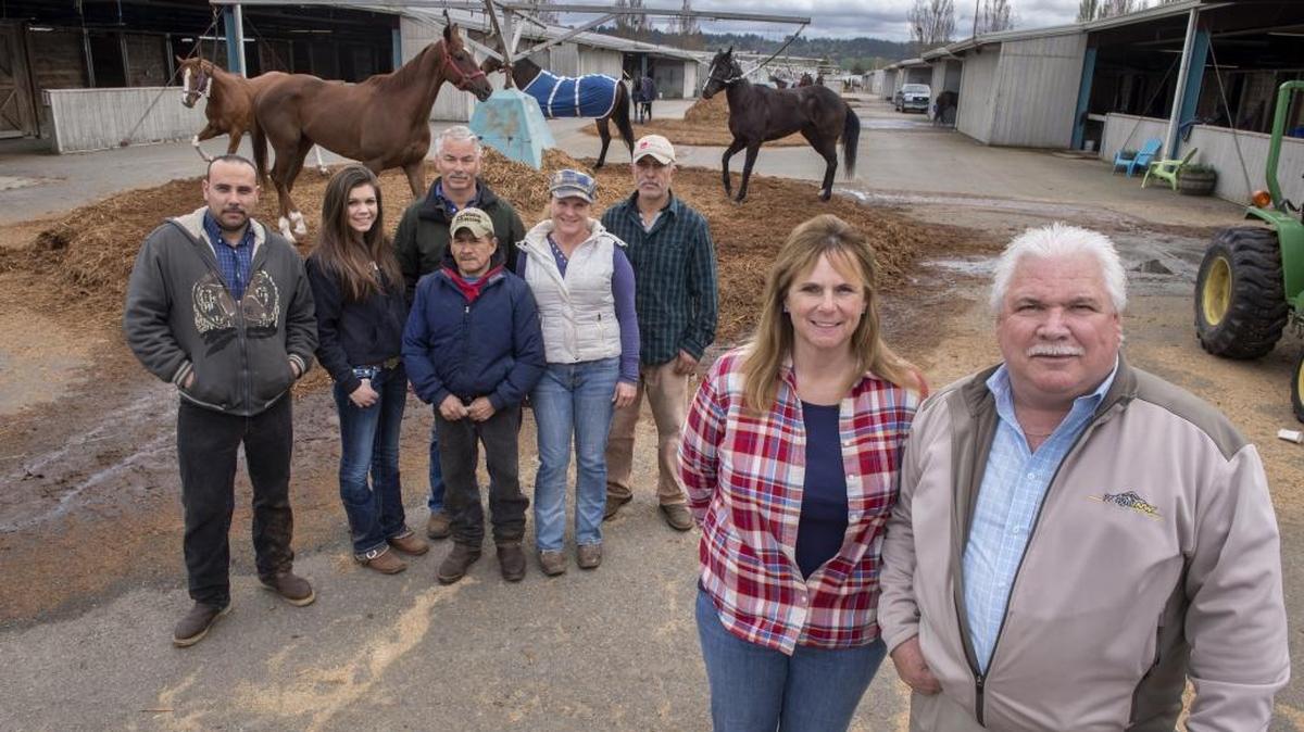 Owner John Parker, right, trainer Candi Tollett, second from right, and the rest of the racing team in the stables of Emerald Downs in Auburn on Tuesday. Parker, who finished second in the owner standings last year, is hoping for 25 wins this season. Back row from left: Alex Armenta, Emily Parker, Darryl Tollett, Raudel Faustino, Tricia Mix and Jose Miguel Rodriguez.