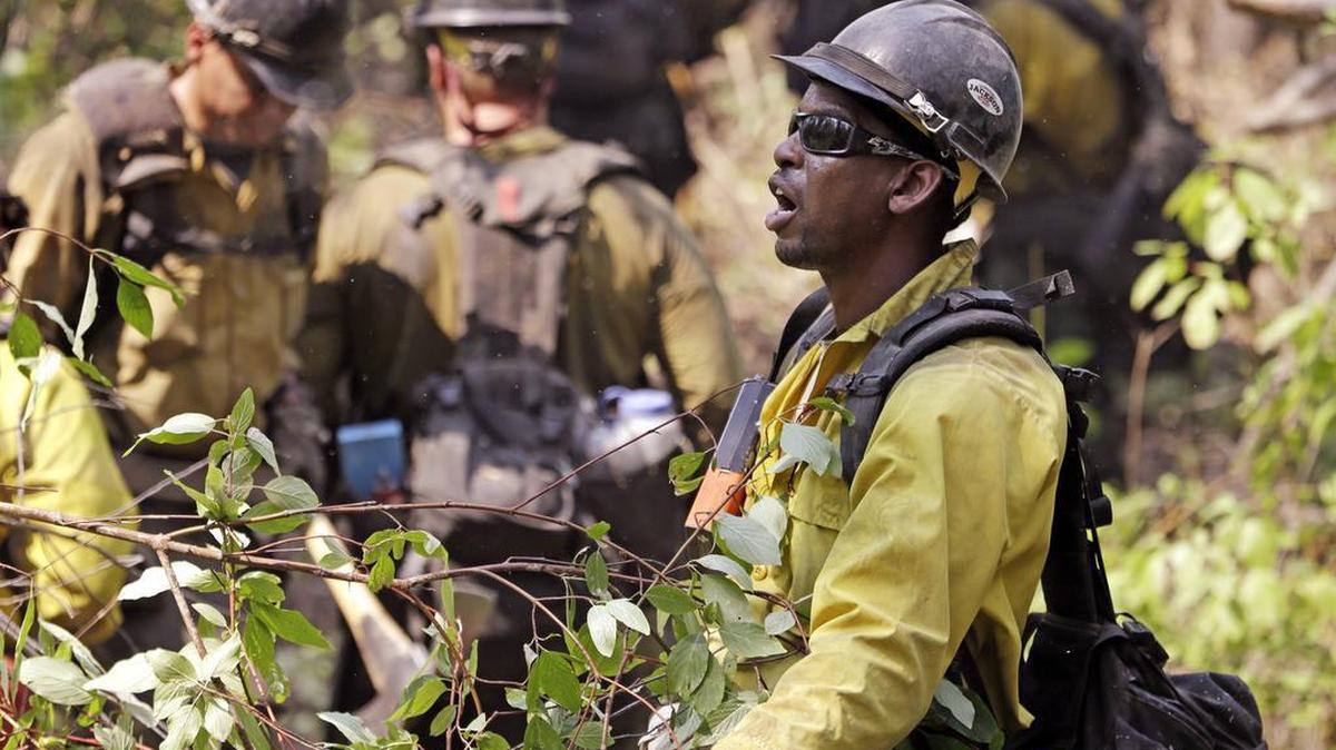 
A firefighter yells out to crew members working on a line Thursday, Aug. 20, 2015, in Twisp, Wash. Authorities warned that more high winds Thursday could make conditions very challenging.
