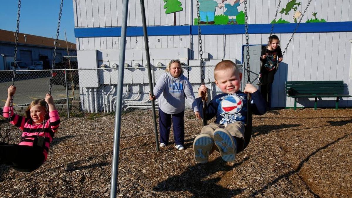 Karen Pszonka, center, pushes grandson Liam on a swing along with granddaughters Peighton, left, and Basia, right, at the playground she and husband Tom built in honor of grandsons Wyatt and Hunter, who died in the Oso landslide, at the preschool the boys attended in Arlington, Wash.
