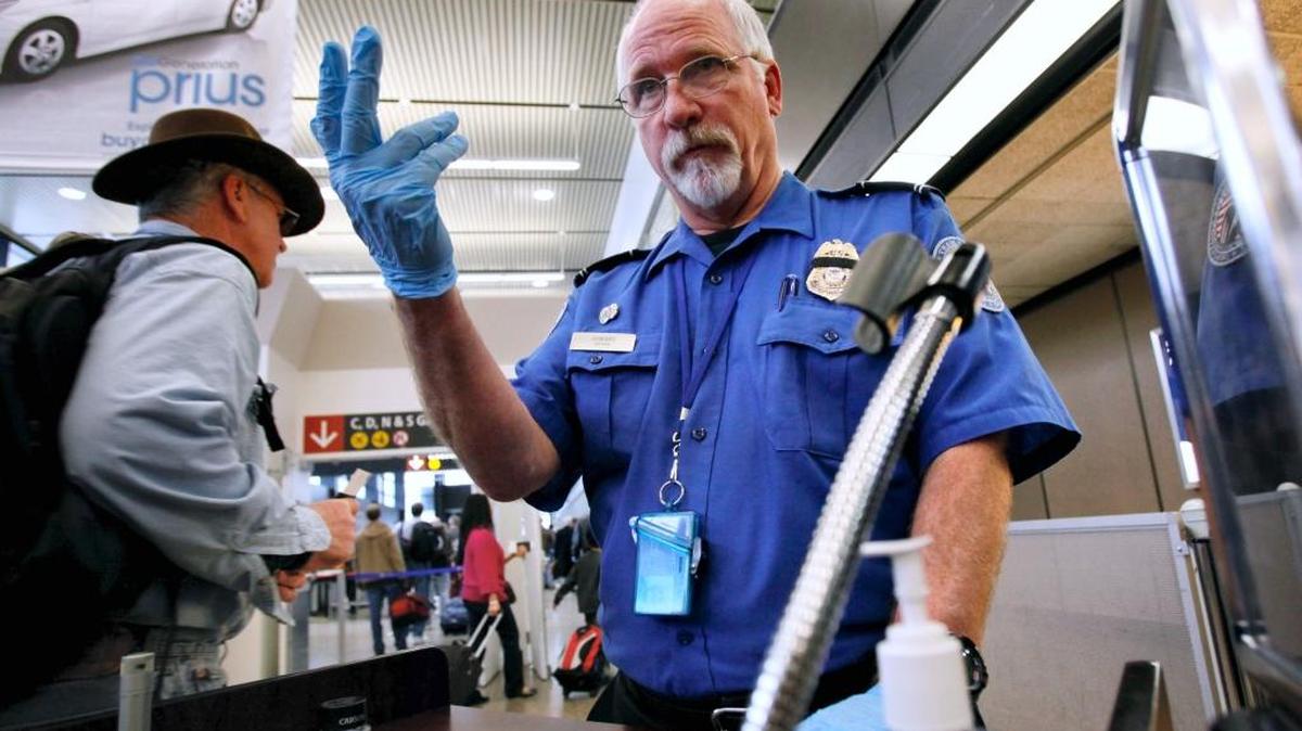 TSA officer Robert Howard signals an airline passenger forward at a security check-point at Seattle-Tacoma International Airport, in January 2010. Passengers departing Sea-Tac Tuesday may have seen a robot providing tips for getting through security faster.