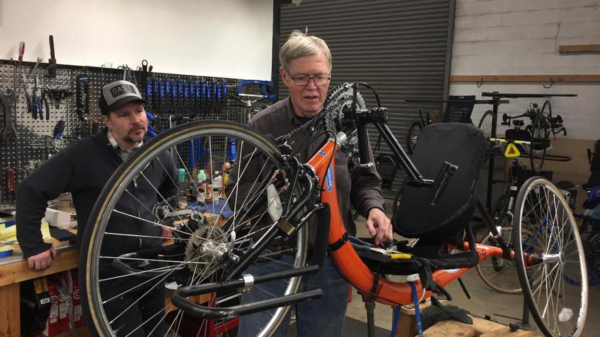 Sherman Coventry, right, works on a hand cycle at Different Spokes, a bike shop in Portland that specializes in adaptive cycles. Adam Amundsen, a co-owner of the shop who has been active in the effort to add adaptive bikes to the city's bike share program, is at left. 