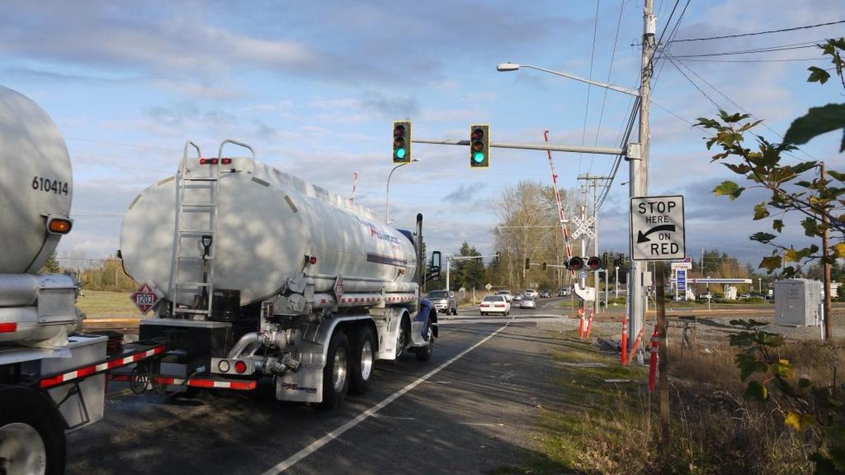A tanker truck prepares to cross the railroad tracks intersecting Grandview Road. Crossing a train with a tanker truck presents a big risk to not just the occupants of the train and truck, but also the surrounding community, and the rules about driving trucks carrying hazardous materials over train tracks align with the potential risk.
