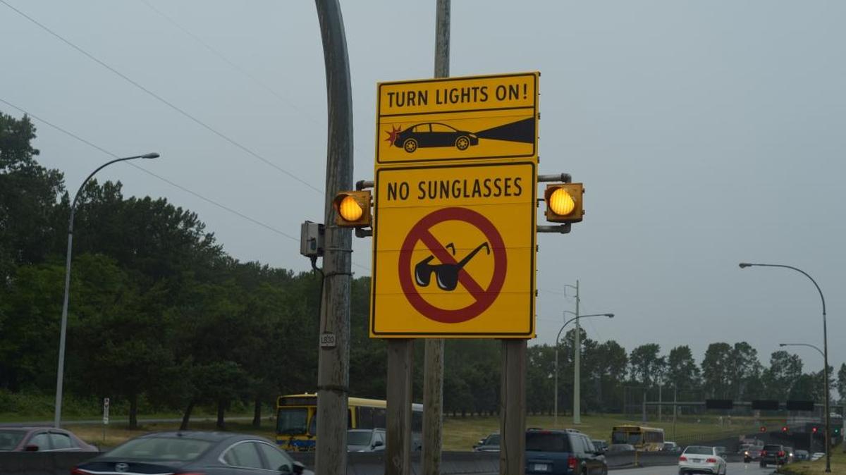A yellow sign is a caution or advisory, so while it’s advised to remove sunglasses at a tunnel, it likely would be safer to keep prescription lenses on than look around the car for another pair of glasses or remove them altogether, limiting your sight.