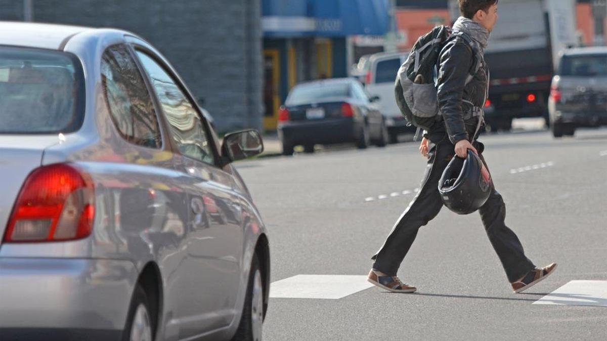 A car stops while a pedestrian crosses North State Street at East Maple Street, in Bellingham.