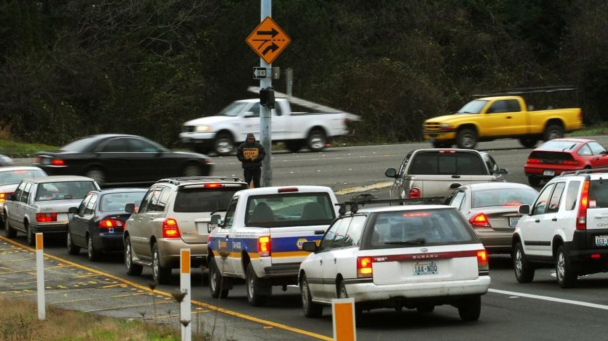 
Cars wait in a line of traffic to turn onto Meridian Street from the Interstate 5 northbound exit ramp in Bellingham in December 2007. Cars turning right onto northbound Meridian Street have a protected lane marked by a solid white line. Cars already on Meridian can’t merge into the right lane until the dashed line, though they often do so illegally.
