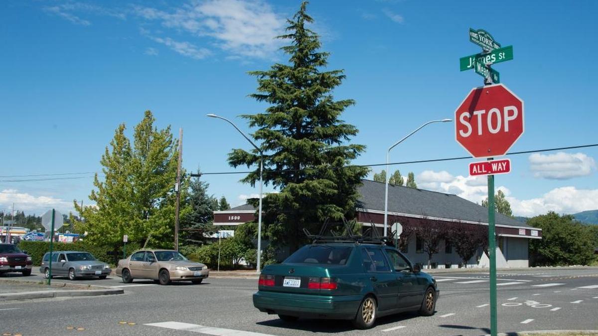 Vehicles take turns driving through a four-way stop at the intersection of James Street and Meador Avenue on Thursday, July 14, in Bellingham. Learning how to make a left-hand turn at an intersection with oncoming traffic attempting to do the same is kind of like learning how to dance with strangers.