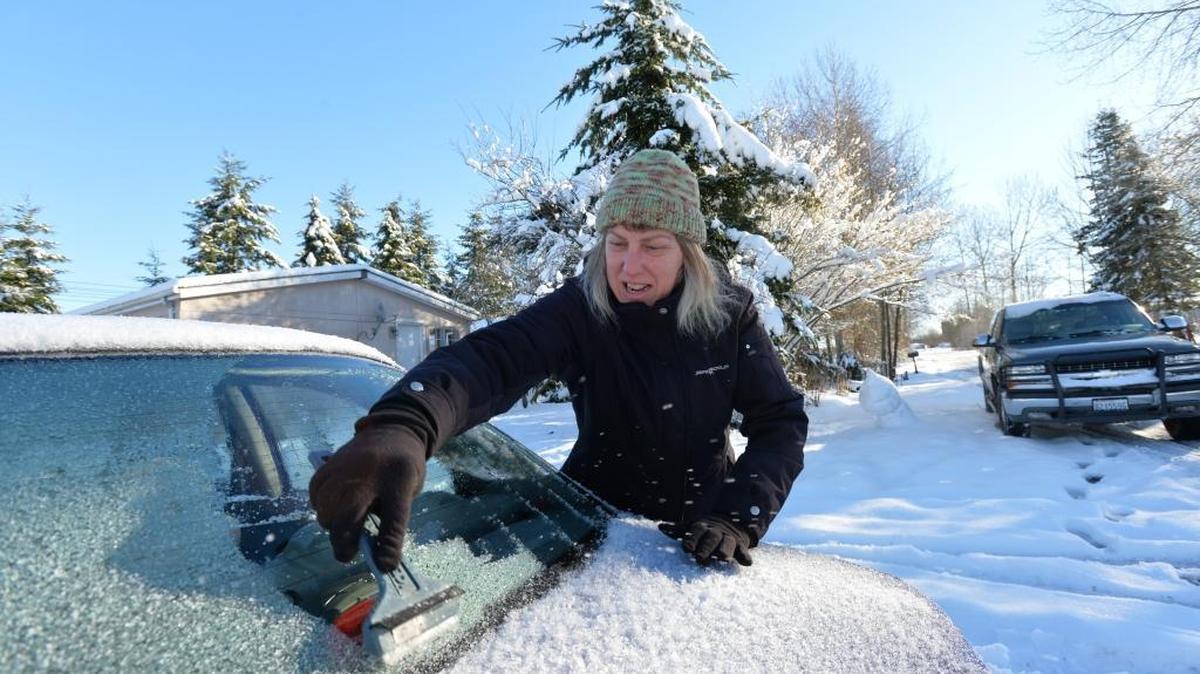 Debbie Quist clears ice off her car before heading to work in February 2014 in Birch Bay. In the state of Washington, “Robin’s Law” addresses unsecured loads, including snow and ice that may slide off your car.