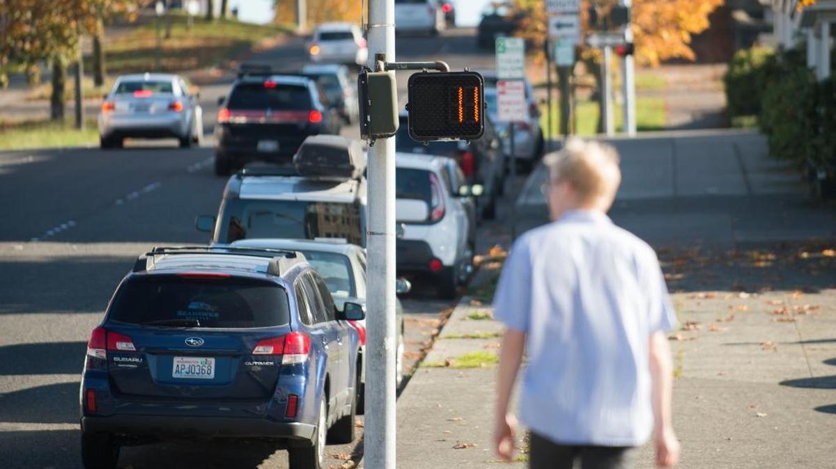 A man walks through a crosswalk as the timer counts down on Thursday, Oct. 26, in Bellingham. Even though it’s against the law to enter a crosswalk when the hand is flashing, being in the intersection then does not increase a pedestrian’s risk.