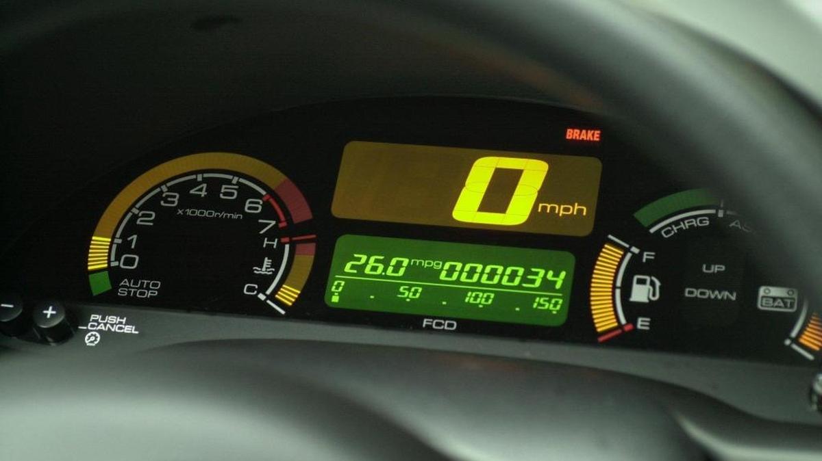Dashboard of an earlier model of the Honda Insight, a gas/electric hybrid. Electric car brake lights may come on when the car is slowing, even when you don’t press the brake pedal.