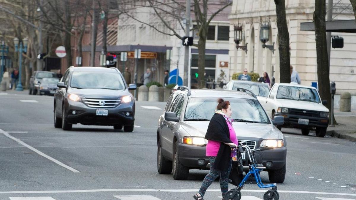 A pedestrian crosses Magnolia Street in downtown Bellingham on Wednesday, Feb. 10. While this is a marked crosswalk, drivers also must yield to pedestrians at unmarked ones.