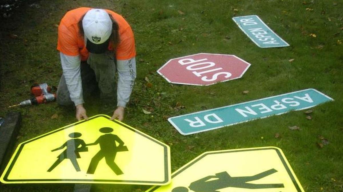 Heath Good of Chandler Construction lays out new road signs for the corner of Aspen Drive and Everson-Goshen Road in Everson in October 2005. If a driver damages any kind of property, whether a sign, a fence or another car, the driver is required to make a reasonable effort to notify the property owner. Failure to do so is a misdemeanor.