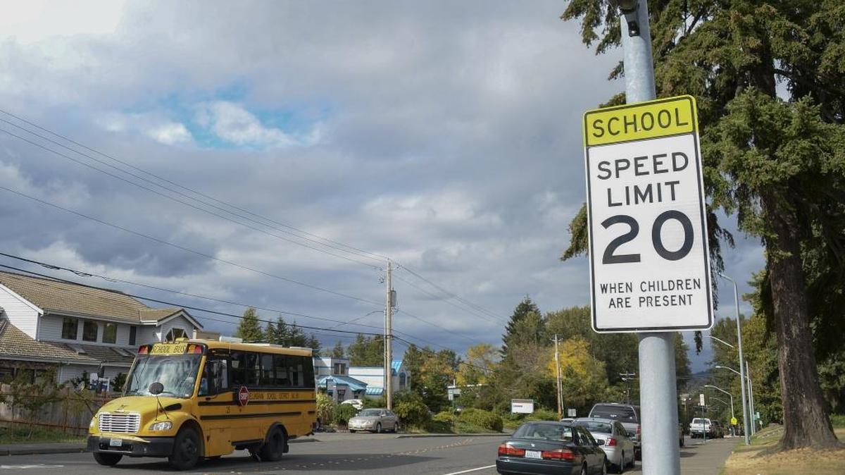 A school zone sign in front of Carl Cozier Elementary on Lincoln Street in Bellingham. School zones require drivers to slow down to 20 mph. The zone extends at least 300 feet beyond a school or a crosswalk to help keep younger pedestrians safe.